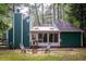 Charming home featuring green siding, sunroom and lush backyard at 90 Oak Leaf Ln, Chapel Hill, NC 27516