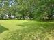 Expansive backyard featuring a lush green lawn and mature trees offering plenty of shade at 912 E Pope St, Dunn, NC 28334