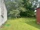Expansive backyard featuring lush green grass, mature trees, and a shed, offering serene outdoor space at 912 E Pope St, Dunn, NC 28334