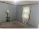 Cozy bedroom featuring neutral carpet, a side table with lamp, and light-blocking curtains at 912 E Pope St, Dunn, NC 28334