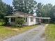 Cozy one-story home with a covered porch and a convenient carport, nestled among mature trees at 912 E Pope St, Dunn, NC 28334
