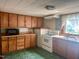 Functional kitchen with wooden cabinets, a stainless steel sink, and updated appliances, ready for cooking at 912 E Pope St, Dunn, NC 28334
