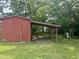 Exterior view of a red storage shed in a backyard with a sheltered work area at 912 E Pope St, Dunn, NC 28334