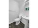 Clean, white bathroom showcasing a pedestal sink and toilet on modern wood-look floors at 916 Waring St, Durham, NC 27704
