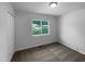 Cozy bedroom boasts a bright window view and neutral carpeting, freshly painted in light gray at 916 Waring St, Durham, NC 27704