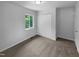 Cozy bedroom with neutral carpet, a window with treed view and closet with bi-fold doors at 916 Waring St, Durham, NC 27704