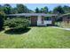 Cozy brick home featuring a well-maintained lawn and mature landscaping, creating a welcoming curb appeal at 916 Waring St, Durham, NC 27704