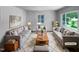 Bright living room with large windows, plush seating, stylish decor, and a cozy rug creating an inviting space at 916 Waring St, Durham, NC 27704