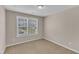 Cozy bedroom with neutral carpet, two windows providing natural light, and light color walls at 960 Sandyhill Rd, Wendell, NC 27591
