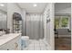Well lit full bathroom features shower with curtain and decorative shelving at 9801 Honeycutt Rd, Raleigh, NC 27614