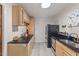 Kitchen with stainless steel appliances, light wood cabinets, and dark countertops offers ample space for cooking and storage at 9801 Honeycutt Rd, Raleigh, NC 27614