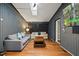 Bright living room featuring hardwood flooring, a skylight, and a mounted television at 9801 Honeycutt Rd, Raleigh, NC 27614