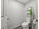 Clean half bathroom with a toilet, shelving unit with decor, and toilet paper stand at 9801 Honeycutt Rd, Raleigh, NC 27614