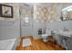 Well-lit bathroom with white tile, modern fixtures, and wooden floors at 1000 College St, Oxford, NC 27565
