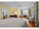This primary bedroom features a bay window, wood floors, and space for a sitting area at 1000 College St, Oxford, NC 27565