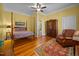 Comfortable bedroom with yellow walls, a four-poster bed, and a patterned rug at 1000 College St, Oxford, NC 27565
