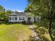 Aerial view showcasing the home's architecture, landscaping, and spacious yard, surrounded by mature trees at 1000 College St, Oxford, NC 27565