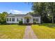 Charming one-story home with a well-manicured lawn, inviting front porch, and classic architectural details at 1000 College St, Oxford, NC 27565