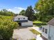 Aerial view of a garage with three bays, showcasing its driveway and landscaping, set amongst mature trees at 1000 College St, Oxford, NC 27565
