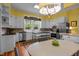 The kitchen features white cabinetry, hardwood floors, stainless appliances and a window with floral valance at 1000 College St, Oxford, NC 27565
