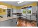 The kitchen features white cabinetry, hardwood floors, a center island and a window with floral valance at 1000 College St, Oxford, NC 27565