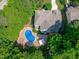 Overhead shot of a home with a vibrant blue pool, patio, and verdant trees around the property at 101 Quarryrock Rd, Holly Springs, NC 27540