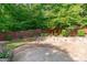 Private backyard features a stone patio, a wooden fence, and lush landscaping at 101 Quarryrock Rd, Holly Springs, NC 27540