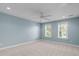 Light blue bedroom with lots of light, two windows, and a ceiling fan, offering a bright and inviting space at 101 Quarryrock Rd, Holly Springs, NC 27540