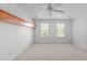 Inviting bedroom with neutral walls, two sunlit windows, wood trim, and a ceiling fan, creating a comfortable space at 101 Quarryrock Rd, Holly Springs, NC 27540