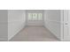 Well-lit bonus room with plush neutral carpet, white trim and walls and a centered window at 101 Quarryrock Rd, Holly Springs, NC 27540
