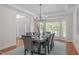 Bright dining room with a modern chandelier, set table for six, and view to the entry hall at 101 Quarryrock Rd, Holly Springs, NC 27540