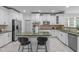 Bright kitchen with white cabinetry, stainless steel appliances, an island, and bar stool seating at 101 Quarryrock Rd, Holly Springs, NC 27540