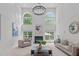 Bright living room features a fireplace, large windows and high ceilings with modern chandelier at 101 Quarryrock Rd, Holly Springs, NC 27540