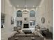 Grand living room with high ceilings, a fireplace, large windows, and elegant neutral furniture at 101 Quarryrock Rd, Holly Springs, NC 27540