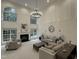 Bright living room with soaring ceilings, a fireplace, large windows, and comfortable neutral furnishings at 101 Quarryrock Rd, Holly Springs, NC 27540