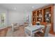 Well-lit office with wood floors, a built-in bookcase, and a white modern desk with two accent chairs at 101 Quarryrock Rd, Holly Springs, NC 27540