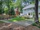 Spacious backyard featuring a hammock, patio area, lush lawn, and mature trees for privacy at 102 Turnberry Ln, Cary, NC 27518