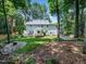 Lush backyard with a stone fire pit, inviting patio, and mature trees at 102 Turnberry Ln, Cary, NC 27518