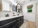 Bright bathroom with double sink vanity, black cabinets and modern fixtures, alongside a window at 102 Turnberry Ln, Cary, NC 27518