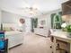 Comfortable bedroom with a ceiling fan, neutral color scheme, and bright windows with green curtains at 102 Turnberry Ln, Cary, NC 27518