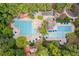 An aerial view shows the community pool and recreation area surrounded by lush trees at 102 Turnberry Ln, Cary, NC 27518