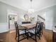 An elegant dining room features light green walls, a dark wood table and is adjacent to the kitchen at 102 Turnberry Ln, Cary, NC 27518