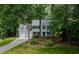 Charming two-story home featuring a manicured lawn, mature trees, and a two-car garage at 102 Turnberry Ln, Cary, NC 27518