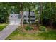 Beautiful light blue home with a two-car garage, complimented by flowering shrubbery and a manicured lawn at 102 Turnberry Ln, Cary, NC 27518