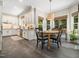 Bright eat-in kitchen boasts white cabinetry, stainless appliances, and a dining nook with wooded views at 102 Turnberry Ln, Cary, NC 27518