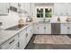 Bright kitchen with white cabinets, stainless steel dishwasher, granite countertops, and natural light at 102 Turnberry Ln, Cary, NC 27518