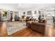 Open concept living room with hardwood floors, leather furniture and a view into the kitchen area at 102 Turnberry Ln, Cary, NC 27518