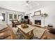 Cozy living room features a white brick fireplace, hardwood floors, and access to outdoor patio at 102 Turnberry Ln, Cary, NC 27518