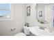 Half bathroom with decorative mirror, window and pedestal sink at 102 Williamson Place Dr, Princeton, NC 27569