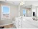 Bright bathroom featuring double sinks, white cabinetry, large mirror, and an open window at 102 Williamson Place Dr, Princeton, NC 27569